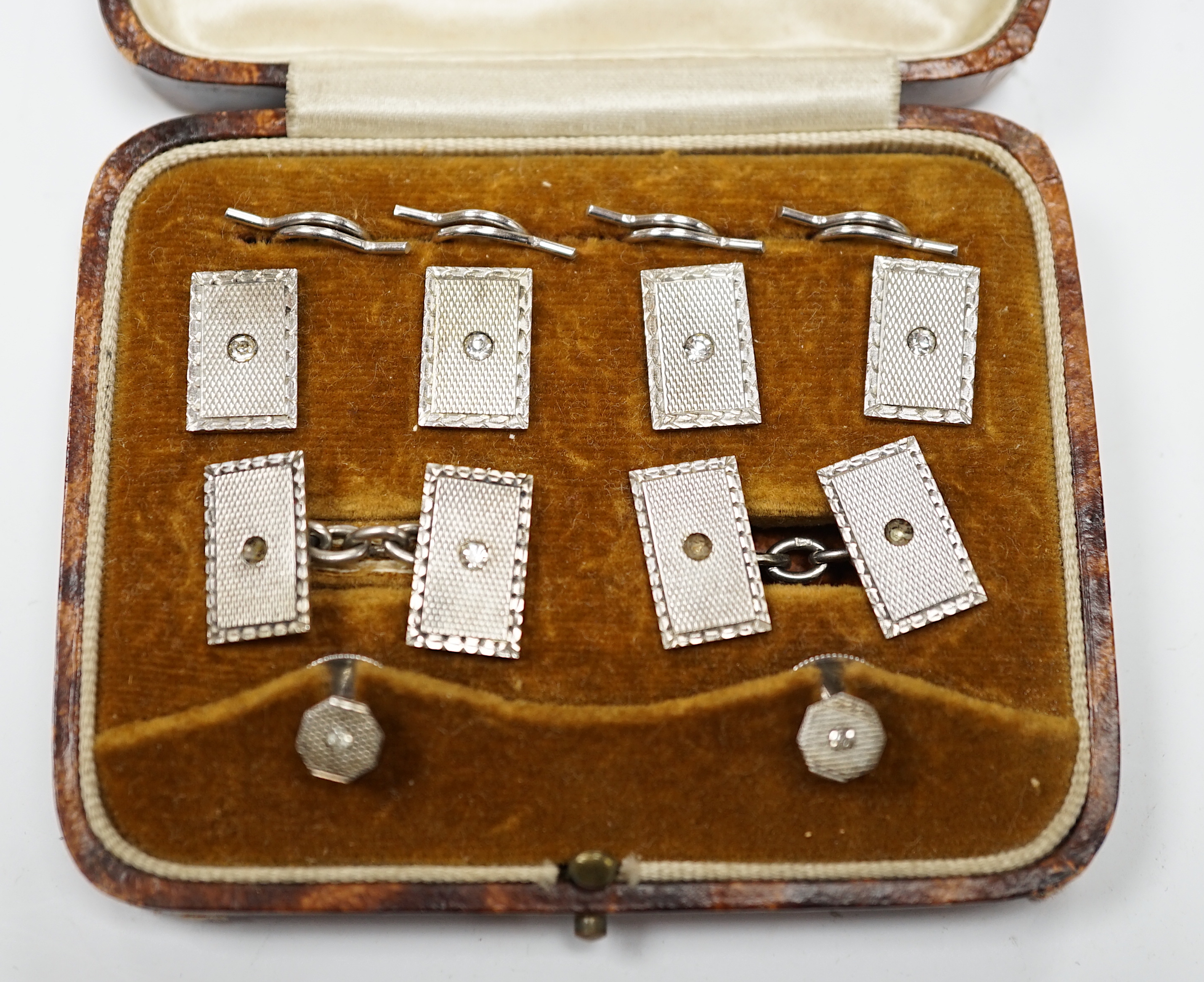 A cased George V engine turned silver and paste set eight piece dress stud set, Henry Griffith & Sons Ltd, Chester, 1934.